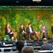 Four panelists sitting on a stage, during the side event