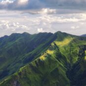 Green forested mountains with a cloudy sky