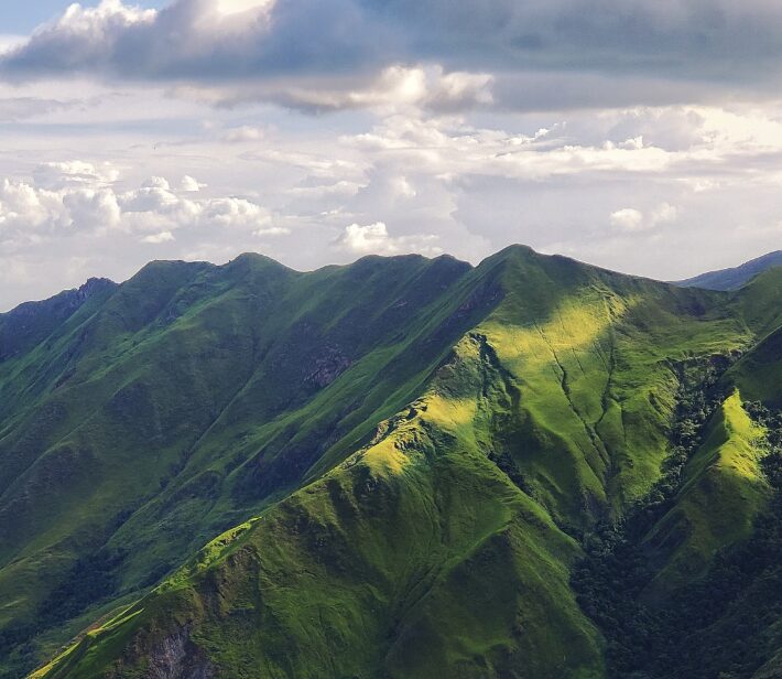 Green forested mountains with a cloudy sky